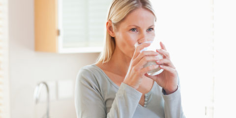 Woman in the kitchen drinking water