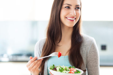 braunhaarige Frau mit Schüssel Salat in der Hand